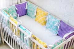 How should I wash the bumpers in a newborn crib?